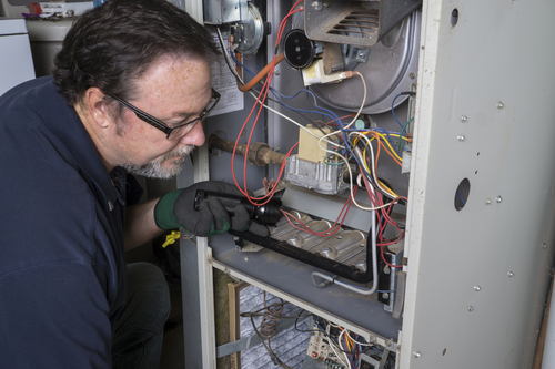 Technician servicing a furnace in Centrl Indiana